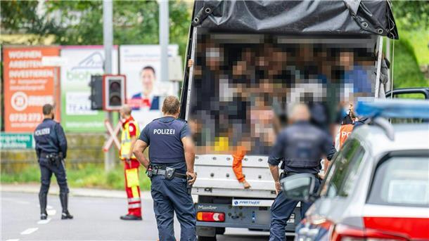Menschenschmuggel: Lkw mit 53 Menschen in Linz gestoppt Polizisten stehen bei einer Kontrolle in Österreich an einem Kleintransporter. Die Beamten entdeckten dabei 53 Personen auf der Ladefläche.