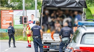 Polizisten stehen bei einer Kontrolle in Österreich an einem Kleintransporter. Die Beamten entdeckten dabei 53 Personen auf der Ladefläche.