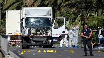 Polizisten stehen um den Lastwagen, mit dem der Attentäter in Nizza in eine Menschenmenge an der Strandpromenade gerast war.