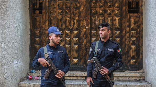 Gaza trauert um Tote nach Brand in Wohnhaus Polizisten stehen vor einem dreistöckigen Wohnhaus in einem Flüchtlingslager, in dem nach einem Brand mehrere Menschen gestorben sind.
