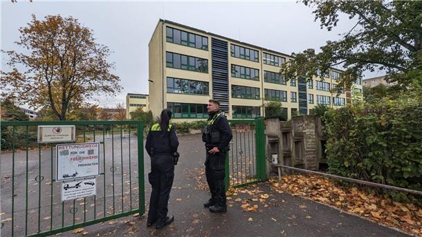 Erneut Welle von Bombendrohungen an Schulen Polizisten stehen vor einer Schule in Erfurt.