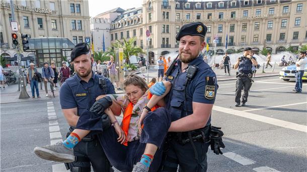 Polizisten tragen auf der Kreuzung am Stachus in der Münchener Innenstadt Aktivisten der Letzten Generation weg. Ihre Aktionen werden teilweise verboten.