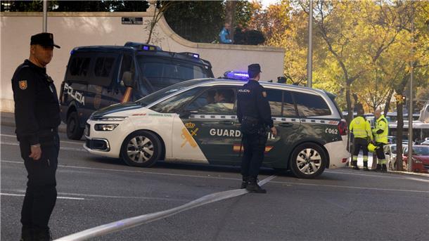 Polizisten und Feuerwehrleute stehen vor der US-Botschaft in Madrid, wo eine Briefbombe einging.
