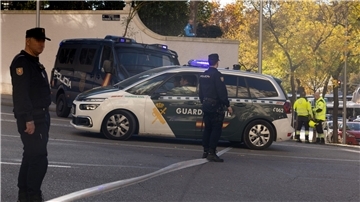 Polizisten und Feuerwehrleute stehen vor der US-Botschaft in Madrid, wo eine Briefbombe einging.