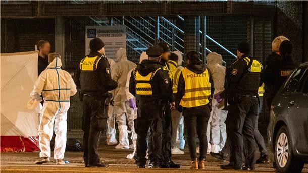 Polizisten und Mitarbeiter der Spurensicherung stehen vor dem Gebäude der Zeugen Jehovas.