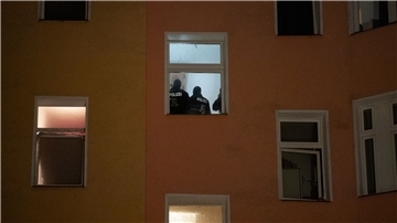 Polizten sind am Morgen im Treppenhaus eines Wohnhauses zu sehen.