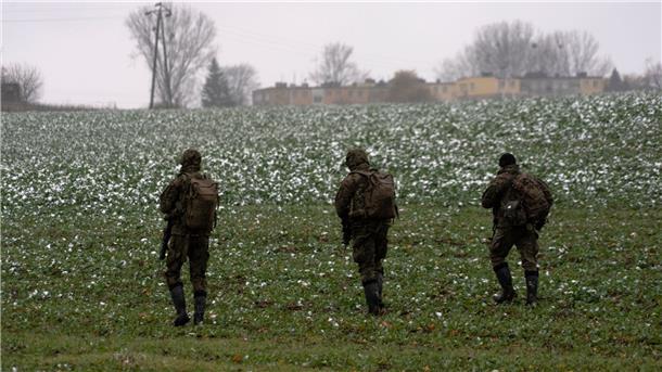 Krieg gegen die Ukraine: So ist die Lage Polnische Soldaten suchen auf einem Acker nach Wrackteilen.