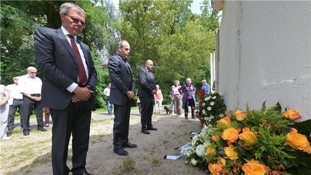 Potsdams Bürgermeister Burkhard Exner (SPD, l-r), Groß Glienickes Ortsvorsteher Winfried Sträter und Berlins Spandaus Bürgermeister Frank Ewig (CDU) gedenken an einem alten Stück Berliner Mauer, das ein Teil der Mauergedenkstätte im Gutspark Groß Glienicke ist, an den Mauerbau.
