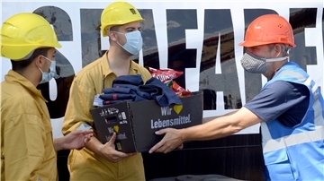 Präsente zum Tag der Seefahrer: Diakon Dirk Obermann von der Seemannsmission mit Besatzung der „MSC Ambra“.