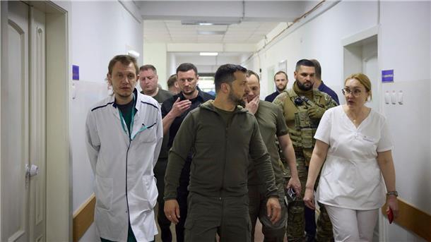 Präsident Selenskyj (M) besucht ein Krankenhaus in dem von den Überschwemmungen betroffenen Gebiet von Cherson.