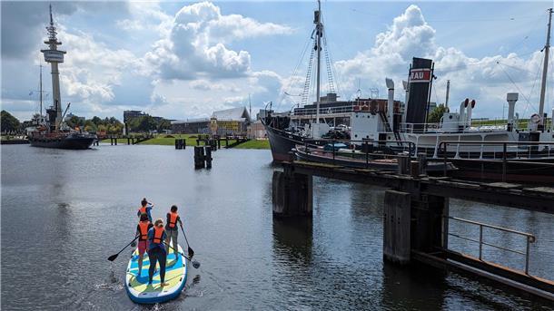Premiere im Museumshafen: Das Deutsche Schifffahrtsmuseum hat zusammen mit "Ins Blaue" aus Bremen SUP-Paddeln zwischen den Museumsschiffen angeboten.