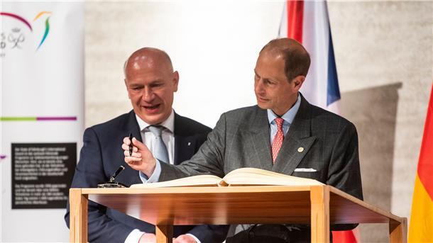 Prinz Edward trägt sich in das Goldene Buch der Stadt Berlin ein. Hinter ihm steht Kai Wegner, Regierender Bürgermeister von Berlin.