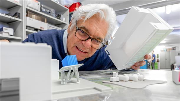 Mann guckt auf Modell des 