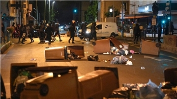 Protestierende blockieren eine Straße mit Mülleimern in Colombes, außerhalb von Paris.