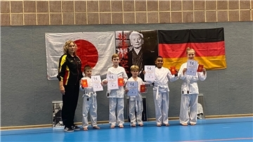 Prüferin Dina Keller mit (von links) den Karate-Talenten Robin Buttmann, Finn Benecke, Johann Menke, Mike Daum und Niklas Sundmacher.