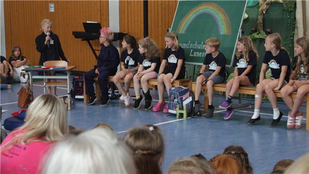 Kinder sitzen auf Bänken
