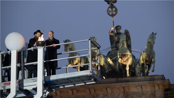 Schatten über Lichterfest: Viele Ängste und Sorgen Rabbiner Yehuda Teichtal (l.) und Bundeskanzler Olaf Scholz zünden beim traditionellen zentralen Chanukka-Lichterzünden am Brandenburger Tor in Berlin ein Licht an.
