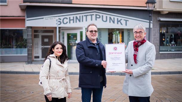 Drei Leute vor einem Friseursalon