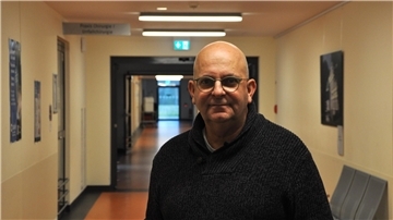 Mann mit Brille in einem schwarzen Pullover