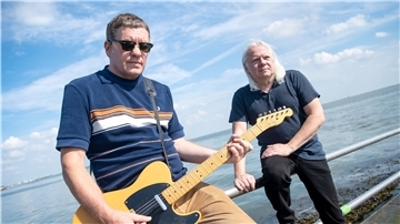 Ralf Lübke (l), Musiker, und Heiko Krebs, Cutter des Videos, stehen am Wilhelmshavener Südstrand. 40 Wilhelmshavener Musiker haben in der Corona-Krise ein Video als Lebenszeichen produziert.
