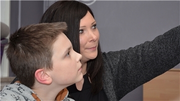 Ramona Nauck sitzt mit ihrem Sohn Dean im heimischen Wohnzimmer. Der Junge leidet an Asperger-Autismus und ADHS.