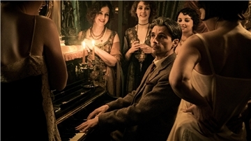 Ein Mann am Klavier, umgeben von Frauen.