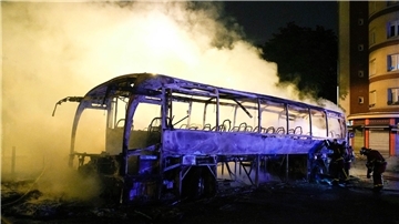 Rauch steigt bei nächtlichen Krawallen aus einem ausgebrannten Bus in Nanterre.