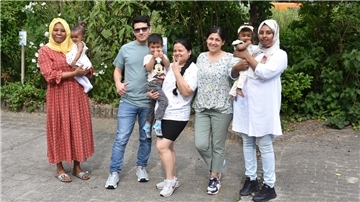 Vier Frauen, ein Mann und drei Kinder posieren für ein Foto.
