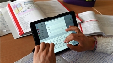 Realschüler einer zehnten Klasse einer Gemeinschaftsschule arbeiten in einer Unterrichtsstunde mit Tablets.