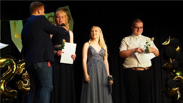 Realschul-Zweigleiter Thore Friemann gratuliert den Klassenbesten (RS10) Celine Rehbock, Mia Charleen Schimmel und Olaf Kazimierczuk.
