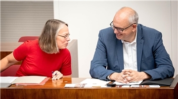 Eine Frau und ein Mann sitzen nebeneinander. 