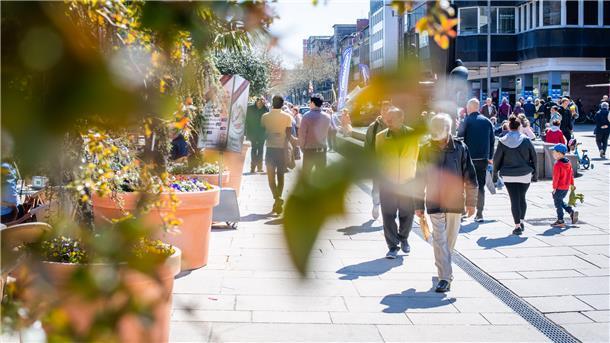 Regionales Einzelhandelskonzept: Eine Frau geht mit Einkaufstüten durch die Fußgängerzone.