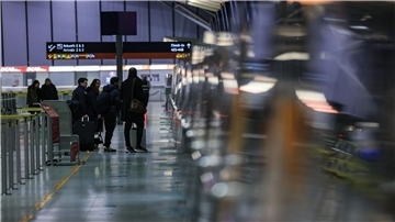 Reisende stehen am Flughafen Köln/Bonn vor einem Schalter.