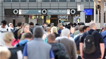 Reisende stehen in einer langen Schlange vor der Sicherheitskontrolle am Hamburger Flughafen an.