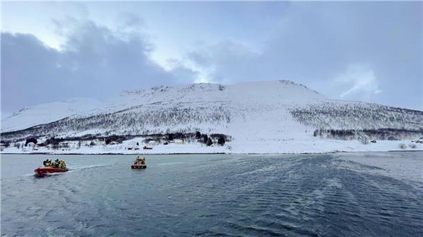 Rettungshelfer suchen nach einer Schneelawine auf der Insel Reinøya mit Booten nach Überlebenden.