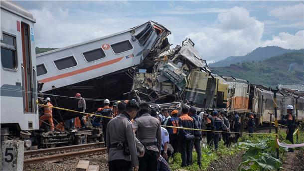 Schweres Zugunglück in Indonesien - mindestens vier Tote Rettungskräfte inspizieren die Zugwracks nach dem Zusammenstoß in Indonesien.