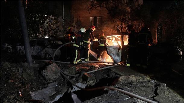 Rettungskräfte löschen in einem geparkten Auto ein Feuer, das nach einem russischen Luftangriff im Kiewer Pecherskyi-Viertel durch herabfallende Trümmer verursacht wurde.
