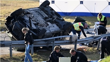 Rettungskräfte und Polizisten am umgestürzten Fahrzeug. Beim Unfall sind sieben Menschen gestorben und mehrere schwer verletzt worden.