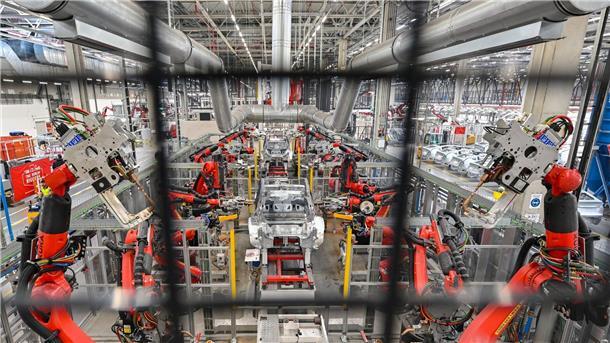 Ein Jahr Tesla-Werk in Deutschland Roboter verschweißen die Karosserie eines Elektrofahrzeuges vom Typ Model Y.