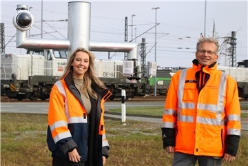 Ein Mann und eine Frau stehen in einem Hafen vor einem Kamerasystem 