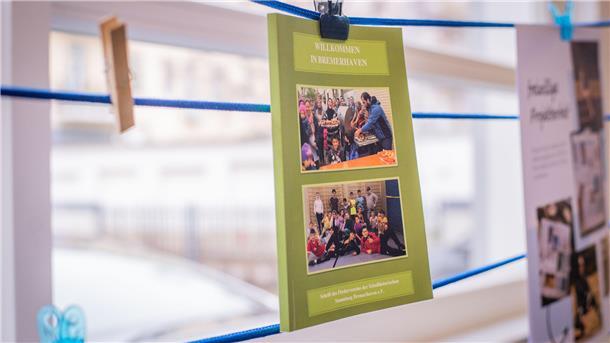 Roswitha Fütterer vom Förderverein der Schulhistorischen Sammlung Bremerhaven zeigt ein Exemplar des Buches "Willkommen in Bremerhaven". Foto: Hartmann
