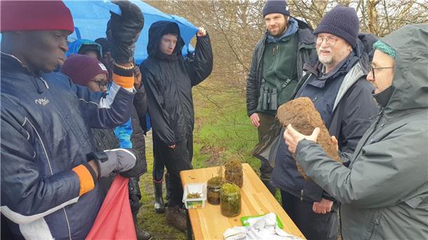 Rüdiger von Lemm (rechts), erklärt der Jugendgruppe, wofür Moos nützlich ist und wie Torf entsteht.