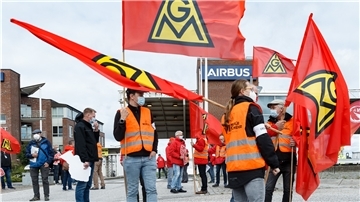Mitarbeiter von Airbus streiken mit Fahnen.