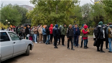 Russen stehen in einer Schlange, nachdem sie die Grenze nach Kasachstan überquert haben.