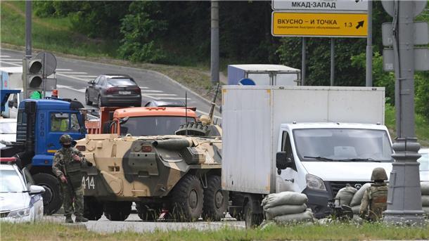 Russische Armeeangehörige bewachen die Autobahn bei Moskau mit einem Mannschaftstransportwagen.