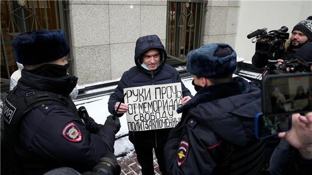 Russische Polizisten halten im vergangenen Dezember einen Mann fest, der vor dem Obersten Gerichtshof in Moskau gegen die Auflösung von Memorial protestiert: „Hände weg von Memorial, Freiheit für politische Gefangene.“