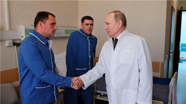 Russlands Präsident Wladimir Putin (r.) während eines Besuchs von verletzten Gefreiten im zentralen Militärkrankenhaus in Moskau.