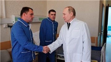 Russlands Präsident Wladimir Putin (r.) während eines Besuchs von verletzten Gefreiten im zentralen Militärkrankenhaus in Moskau.
