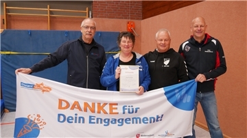 Vier Personen stehen hinter einem Banner
