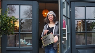 Frau steht in einer Tür mit einem Schild in der Hanbfdn